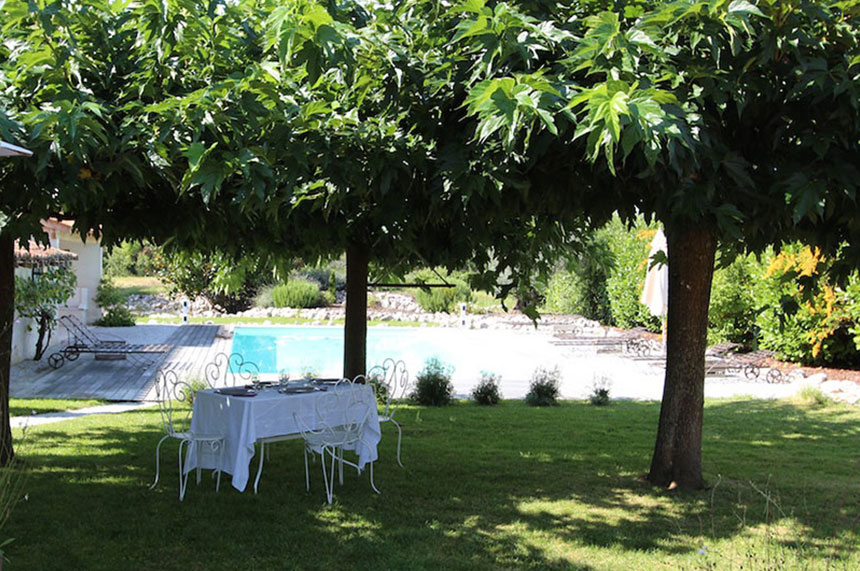 Une table d'hôtes sous les arbres à la belle saison